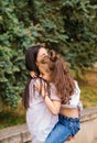 A young woman and her daughter are circling in their arms. Mom and daughter laugh and have fun