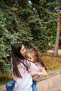 A young woman and her daughter are circling in their arms. Mom and daughter laugh and have fun