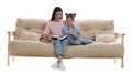 Young woman and her daughter reading book on comfortable sofa against white background Royalty Free Stock Photo