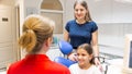 Portrait of young woman with her daughter talking to pediatric dentist