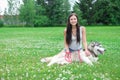 Young women and her dog husky resting near lake in summer