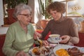 Young woman and her happy grandmother having lunch at restaurant Royalty Free Stock Photo