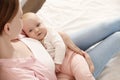 Young woman with her little baby resting after breast feeding on bed Royalty Free Stock Photo