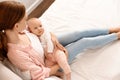 Young woman with her little baby resting after breast feeding on bed Royalty Free Stock Photo