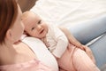 Young woman with her little baby resting after breast feeding on bed Royalty Free Stock Photo