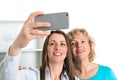 Woman and her mother taking a selfie together in the kitchen Royalty Free Stock Photo