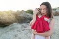 Young woman holding cute baby girl outdoors on the beach, Royalty Free Stock Photo