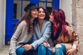 Young women hugging and laughing on city street. Best friends having good time together