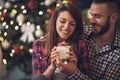 Woman with husband looking at Christmas gift