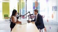 Young woman interviewing a guest in a studio for a podcast