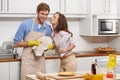 The perfect husband.... A young woman kissing her boyfriend goodbye while hes drying dishes in the kitchen. Royalty Free Stock Photo