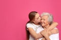 Young woman kissing her grandmother. Space for text Royalty Free Stock Photo