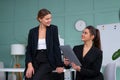 Young women leaders are checking financial statements from paper documents. Two female confident business worker dressed black Royalty Free Stock Photo