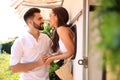 Happy young woman leaning out of trailer window to hug her boyfriend. Camping vacation Royalty Free Stock Photo