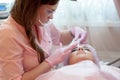 A young woman lies and gets a make-up of her eyebrows in a beauty salon. The use of permanent makeup on the eyebrows. The master w Royalty Free Stock Photo