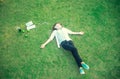 Young women lying in summer grass with headphones listening to music and playing notebook relaxing, Royalty Free Stock Photo