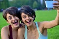 Young women making surprised face while looking at smart phone. Royalty Free Stock Photo
