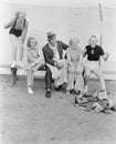 Young women and a man watching a baseball game with enthusiasm