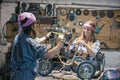 women mechanics repairing children bicycle in workshop