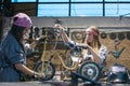 Women mechanics repairing children bicycles in workshop