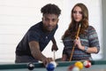 Young men and women in poolroom playing pool team players portrait billiards table nightlife activity Royalty Free Stock Photo