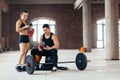 Young woman and man with smartphone and water resting at gym