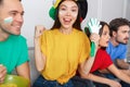 Group of friends sport fans watching match in colorful shirts girl looking camera close-up Royalty Free Stock Photo