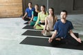 Young women and men in yoga class, relax meditation pose Royalty Free Stock Photo