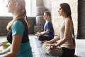 Young women and men in yoga class, relax meditation pose Royalty Free Stock Photo