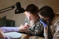 A young woman mentor teacher coach conducts individual training in manicure techniques