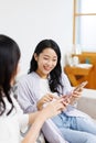 Young  women with mobile phones chatting at home Royalty Free Stock Photo