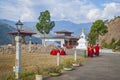 Young women monks of the Buddhist monastery in their traditional red robes before classes next to the prayer wheel. Himalayan moun