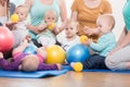 Young women in mother and child group playing with their baby ki