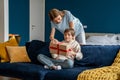 Young woman mother making birthday surprise to excited little boy son at home Royalty Free Stock Photo