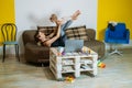 Young woman mother sit on sofa with her baby toddler daughter at home doing yoga exercises, watching online yoga class Royalty Free Stock Photo