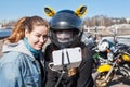 Young women motorcyclists take selfies using cellphone with extensible monopod