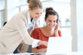 Young women office workers with headset on laptop Royalty Free Stock Photo