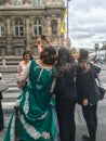 Young women, one in fancy dress, take selfie at Paris street corner