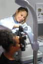 Young woman ophthalmologist checking eye vision of patient for spectacles glasses. Eye health check concept