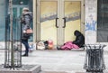 Young women passing homeless man siting in cold weather at close