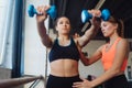 Young woman personal trainer helping with workout at gym Royalty Free Stock Photo