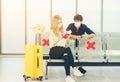 Young women play selfie woth smartphone traveler in protective mask holds passport during affected by flight delay and cancelled