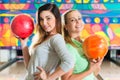 Young women playing bowling and having fun
