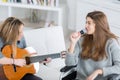 Young women playing guitar while wheelchair friend singing Royalty Free Stock Photo