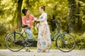 Young women posing by bicycle Royalty Free Stock Photo