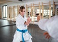 Young women practising karate indoors in gym.