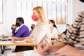 Woman in protective mask listening to lesson in extension school