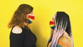 Young women in protective rainbow mask. Side view of two females standing opposite each other in mask lgbt. Royalty Free Stock Photo