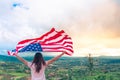 Young women raise national american flag against the blue sky. Independence Day, 4th July