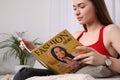 Young woman reading fashion magazine at home, closeup Royalty Free Stock Photo
